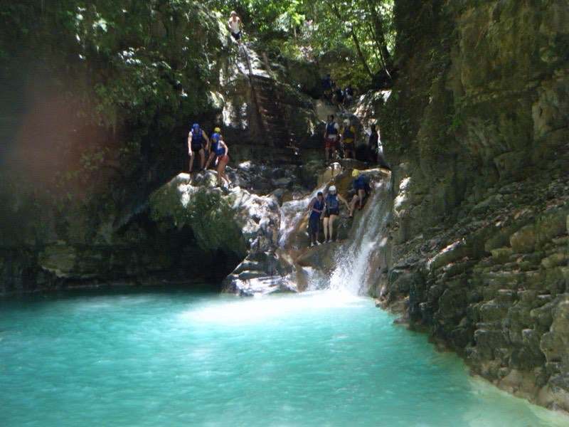 Swimmers climbing turquoise pools at the Damajagua cascades, Dominican Republic